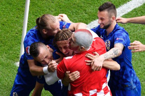 Jubeltraube um Gold-Torschütze Lukas Modric. Dazu mischte sich am Spielfeldrand auch ein kroatischer Fan mit gefärbtem Haupt.