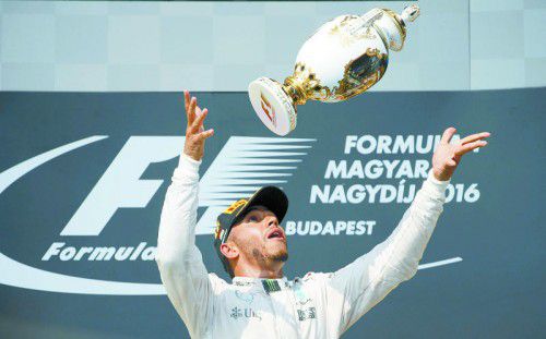 Lewis Hamilton verschafft seiner Freude mit einem Pokalwurf Ausdruck. Der Champion ist nach dem Erfolg in Budapest wieder die Nummer eins in der WM: