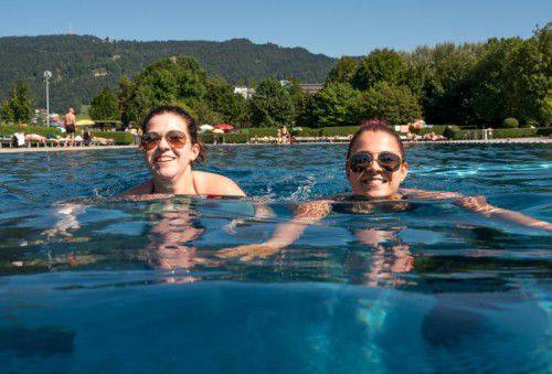 Christina Kuntner (25) aus Dornbirn und Stefanie Fuchsberger (21) aus Lauterach genießen das Sommerwetter im Strandbad Bregenz. Andere Badegäste vergnügen sich auf der Rutsche.