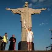 Die olympische Flamme unter der Christus-Statue