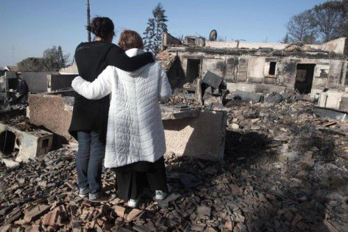 Das Haus dieser beiden Frauen ist völlig niedergebrannt. Es ist eines von 570 Häusern, die bei den Bränden zerstört wurden. Foto: AFP