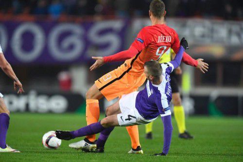 Mit zwei Treffern war Edin Dzeko, im Bild attackiert von Austrias Petar Filipovic, Matchwinner für die AS Roma. Foto: Afp
