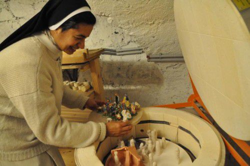 Achtsam nimmt Schwester Maria die Tonfiguren aus dem Brennofen. Foto: cm