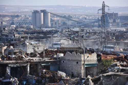 Busse der Regierung fahren durch ein völlig zerstörtes Stadtviertel im südlichen Aleppo. Foto: AFP