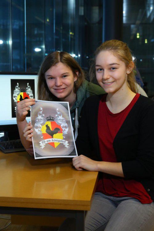 Julia (vorne) und Kathrin zeigen das Titelblatt: der Königshof und sein Wappen.