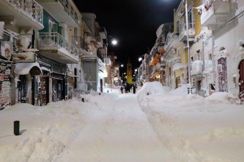Menschen laufen durch das verschneite Santeramo in Colle (Italien). AFP