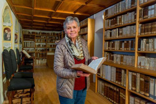 Luzia Dünser in der Bibliothek der Propstei. Seit 13 Jahren führt sie Gruppen und Hausgäste durch die historische Anlage.   Foto: Paulitsch