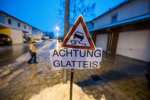 Ein Schild warnt in Straubing vor Glatteis auf dem Gehsteig. Zahlreiche bayerische Gemeinden sind mit derselben Situation konfrontiert. DPA