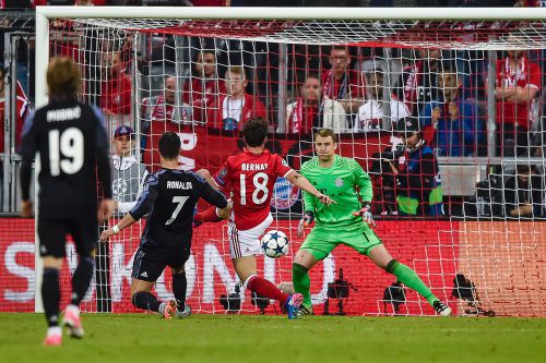 Bayern Münchens Juan Bernat kommt gegen Cristiano Ronaldo zu spät und Real Madrids Superstar bezwingt Tormann Manuel Neuer erneut und erzielt den 2:1-Siegtreffer. Foto: apa