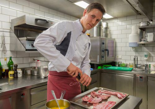 Dominic Mayer würzt die Kaninchenteile vor der Zubereitung mit Salz und Pfeffer. Foto: VN/Paulitsch