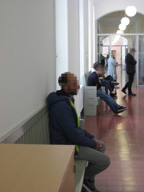 Warten auf die Verhandlung: Der Angeklagte (vorne) und Zeugen vor dem Gerichtssaal in Feldkirch. Foto: Eckert