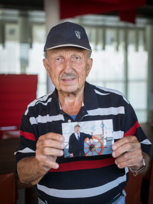 Helmut Schöpf fuhr 65 Jahre zur See. Der pensionierte Kapitän zeigt ein Foto, das ihn am Ruder der „Österreich“ zeigt. Foto: Sams
