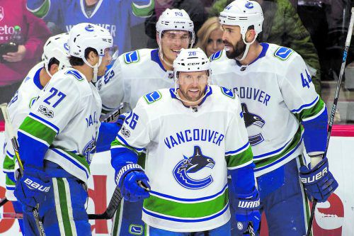 Die Kollegen von Vancouver freuen sich über das Tor von Thomas Vanek (vorne) und den 700. Karrierepunkt des Stürmers in der NHL.  ap