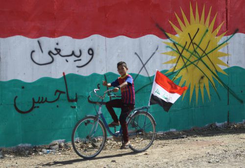 Ein Bub hat sein Fahrrad mit einer irakischen Flagge ausgestattet. Die Mauer im Hintergrund in Dibs nahe Kirkuk ist in den Farben der kurdischen Fahne bemalt. AFP