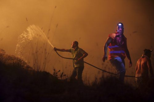Warmer Südwind fachte die Brände an. Am Montag erreichten die Flammenwände Fischerdörfer an der portugiesischen Atlantikküste. AP