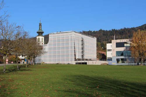 Das neue Gemeinschaftshaus in Lochau ist für die Fassadenarbeiten eingerüstet, auch der neue Dorfplatz vor dem Haupteingang nimmt nun Formen an.  bms