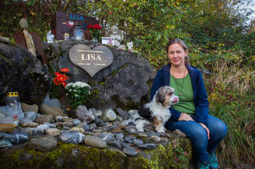 Tamara Bickel (im Bild mit Hund Benny) besucht einmal wöchentlich die Gedenkstätte, die sie für ihre verstorbene Tochter Lisa am Ufer der Ach errichtet hat. VN/Steurer, Privat