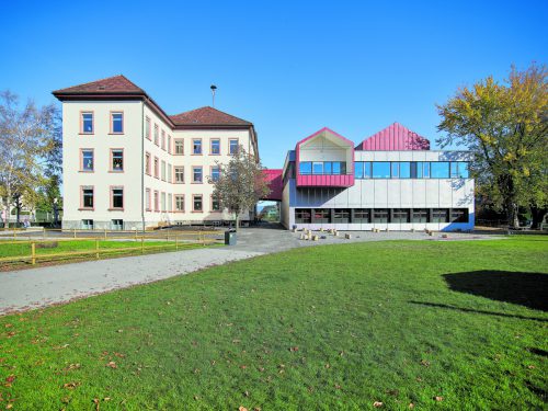 Ein Paar, das sich perfekt ergänzt Der Altbau aus dem Baujahr 1899 hat große Klassen, die Aufstockung des Turnsaales viel Helligkeit, eine offene Bibliothek, Konferenzzimmer und vier Satteldachhäuschen zu bieten.