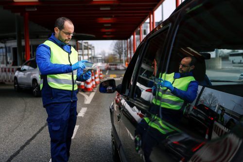 Ein Schweizer Grenzbeamter kontrolliert einen Autofahrer. reuters