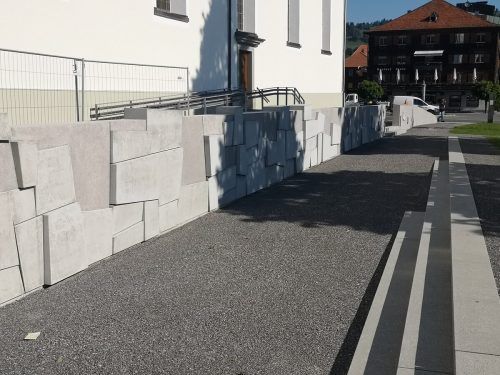 Sitzstufen vor der Mauerskulptur laden zum Verweilen ein.