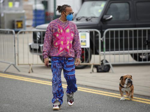 Weltmeister Lewis Hamilton macht sich mit seinem Lieblings-Vierbeiner Roscoe auf den Weg zur Arbeit. reuters