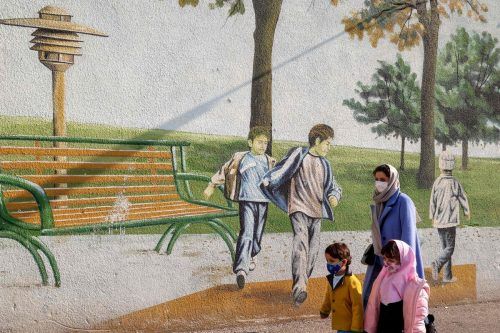 Eine Frau und ihre beiden Kinder passieren ein Wandgemälde in der iranischen Hauptstadt Teheran. AFP