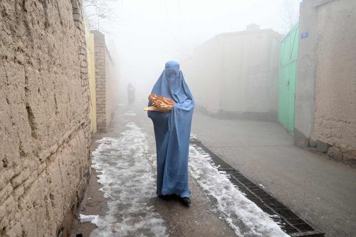 Eine verschleierte Frau holte sich in den Straßen von Kabul kostenloses Brot der "Save Afghans From Hunger" Kampagne. AFP
