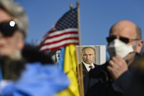 Auf einem Plakat von Demonstranten, die sich am Lincoln Memorial versammelt haben, wird Wladimir Putin mit Adolf Hitler verglichen.  AFP
