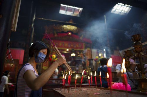 Eine Frau zündet am zweiten Tag des chinesischen Neujahrsfests in einem Tempel in Kuala Lumpur (Malaysia) Kerzen an. AP