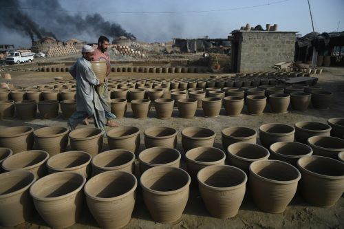 Im pakistanischen Karachi stellen Töpfer ihre frisch angefertigten Erzeugnisse im Freien zum Trocknen auf. AFP