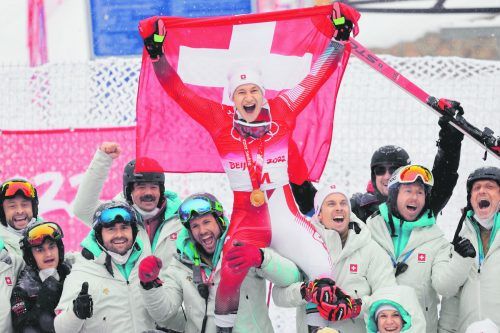 Marco Odermatt feiert mit seinem Team die Riesentorlauf-Goldene. Hinten – mit Ski – sein Vorarlberger Servicemann Chris Lödler. ap