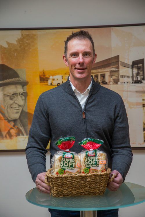 Bernhard Ölz präsentiert vor dem Bild des Firmengründers Rudolf Ölz das neueste Produkt: das vegane Bio-Supersoft Sandwich.  VN/Steurer