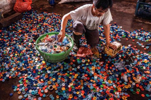 In Surabaya (Indonesien) wurden Flaschenverschlüsse gegen Bustickets gesammelt. Ein Arbeiter trennt sie von Müll, bevor er sie an Recyclingfabriken weiterverkauft. AFP