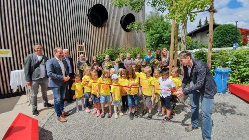 Die Kinder durchschneiden das symbolische Band, das Bürgermeister Dieter Egger und Vizebürgermeisterin Patricia Tschallener halten.