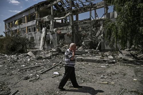 Diese Aufnahme zeigt einen Bewohner von Bachmut vor einem zerstörten Schulgebäude. AFP