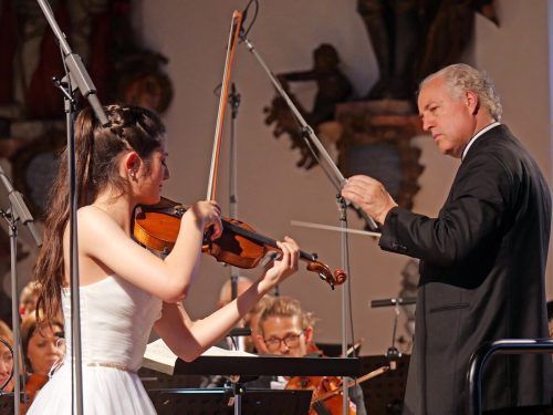 Dirigent Manfred Honeck mit der jungen Geigerin María Dueñas.  voith