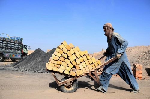In einer Ziegelei in Kandahar, Afghanistan, schiebt ein Arbeiter eine Schubkarre mit den Baumaterialien. AFP