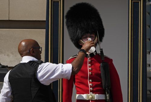 Über 40 Grad in Großbritannien: Ein Polizist leistet einem Wachmann vor dem Buckingham Palast in London Hitzehilfe.  AP