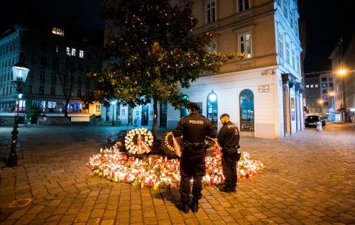 Polizisten stehen am 4. November 2020 vor Kerzen in der Wiener Innenstadt. Zwei Tage zuvor starben vier Menschen bei einem Terroranschlag.  APA/Georg Hochmuth