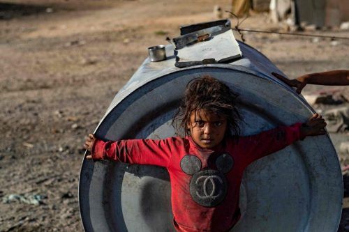 Ein Kind steht vor einem Wassertank im Flüchtlingslager Sahlah al-Banat im Norden Syriens. Die WHO warnt aktuell vor einem Choleraausbruch. AFP