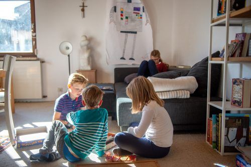 Paul, Johanna und Jakob spielen, Irmgard macht es sich auf dem Sofa bequem. Jeder findet sein Plätzchen. rhomberg