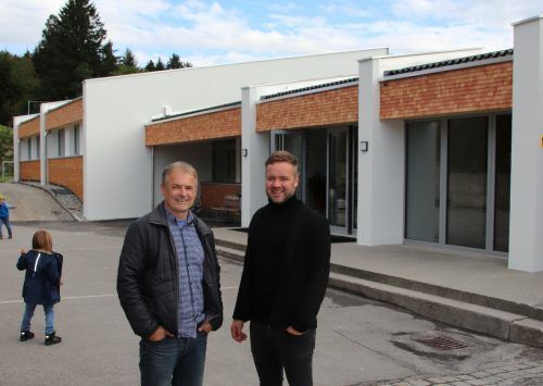 Bgm. Walter Moosbrugger und Bauleiter Stefan Bischof vor der sanierten Schule.