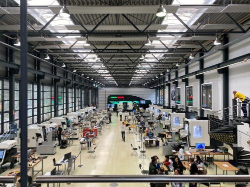 In der Halle finden laufend Wettbewerbe im CNC Drehen und Fräsen statt. Die Teilnehmer aus aller Welt arbeiten in einem Schichtsystem und wechseln sich so an den Maschinen ab.
