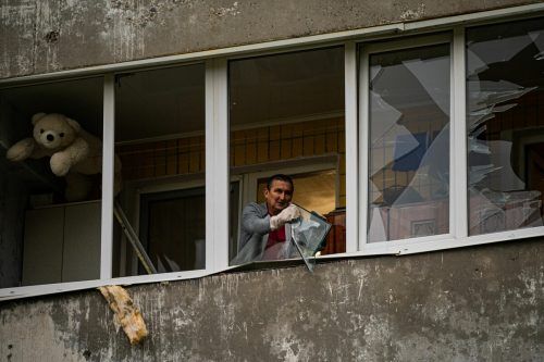 In Dnipro entfernt ein Bewohner kaputte Glasscheiben.