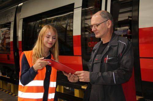 Sheila Huber, Bürokauffrau in der Produktionstechnik, übergibt Klaudius List, Koordinator des Arbeitsteams 1, einen Fertigungsauftrag.