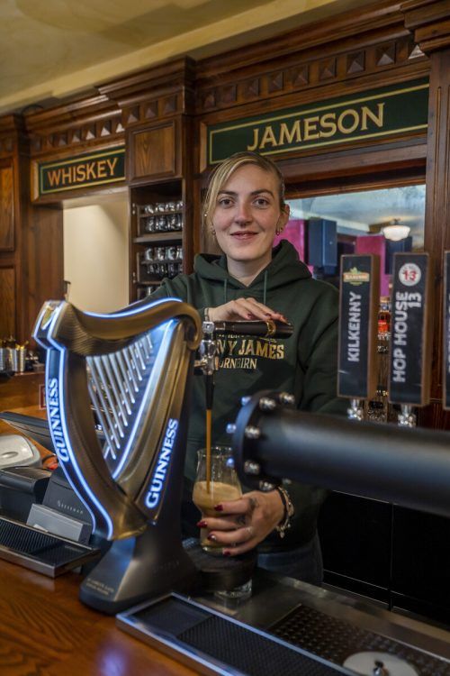 Geschäftsleiterin Jenny Thurnher beim Zapfen der Guinness-Harfe.