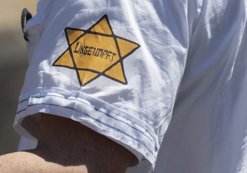 Nachgebildete Judensterne wie dieser mit dem „Ungeimpft“-Schriftzug sollen in Zukunft verboten sein. APA/DPA