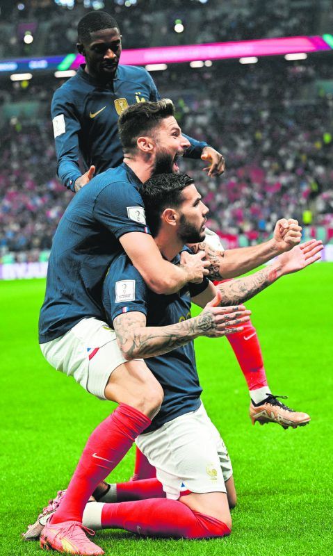 Frankreichs Linksverteidiger Theo Hernández (knieend) feiert seinen frühen Führungstreffer gegen Marokko mit Oliver Giroud (l.) und Ousmane Dembélé. Reuters