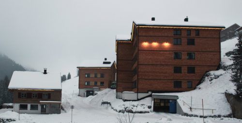 Weihnachtlich mit Lichterketten geschmückt präsentiert sich das Projekt Alpenstolz in Damüls. Links im Bild das Fuchsloch, das weiterhin als Ferienlager angeboten wird.
