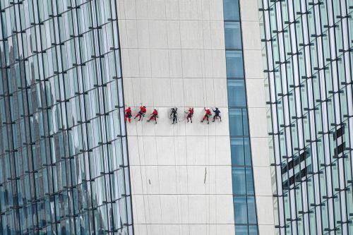 Am Sicherheitsgurt befestigte Arbeiter reinigen die Wand des Hotel- und Resortgebäudes Marina Bay Sands in Singapur. AFP
